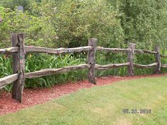 a wooden fence in the middle of a garden