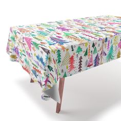 an image of a table cloth with trees and snowflakes printed on it in multicolors