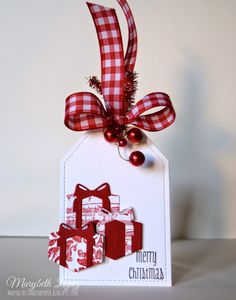 a tag with red and white plaid ribbon hanging from it's side that says merry christmas