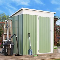 a green and white shed sitting on top of a wooden deck next to a ladder