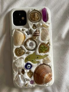 an iphone case with shells, seashells and other sea creatures on white fabric