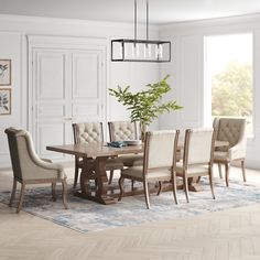 a dining room table and chairs in front of a window with an area rug on the floor