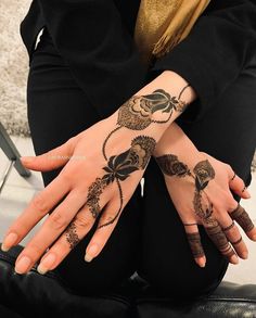 two hands with henna tattoos on them