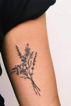 a woman's arm with a flower tattoo on the back of her left arm