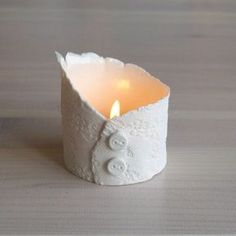 a small white candle holder with an owl on it