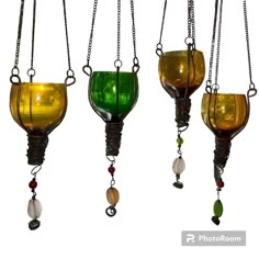 three different colored glass vases hanging from chains on a white background, one is green and the other is yellow