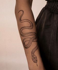 a woman with a snake tattoo on her arm