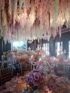 an elaborately decorated dining room with chandeliers and flowers hanging from the ceiling