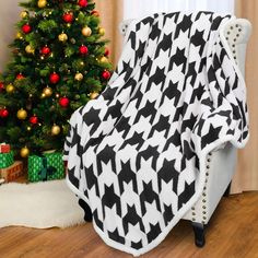 a black and white blanket sitting next to a christmas tree