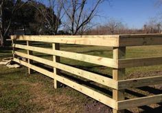 a wooden fence in the middle of a field