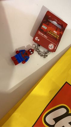 a lego keychain is sitting on top of a table next to a box