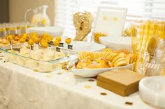 a table topped with lots of food next to glasses and plates filled with desserts