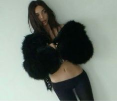 a woman in tights and fur coat posing for the camera