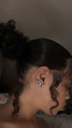 a woman with ear piercings on her ears looking at something in the distance behind her