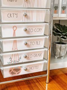 the drawers are organized with clear plastic bins and metal handles, which also have writing on them