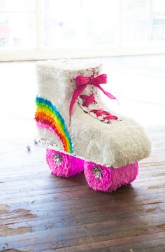 a pair of white and pink roller skates sitting on top of a wooden floor