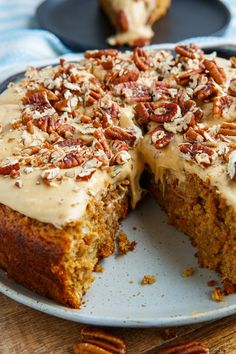 there is a cake that has been cut in half on a plate with pecans around it