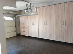 an empty garage with lots of wooden cabinets