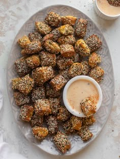 a white plate topped with fried food next to dipping sauce