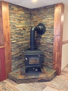 a wood burning stove in a room with stone walls and flooring on the side