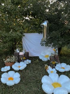 balloons and flowers on the ground in front of a number one sign with other decorations