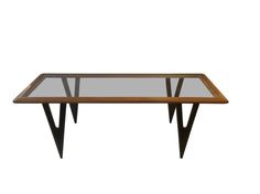 a wooden table with glass top and black metal legs on an isolated white background for use as a coffee table