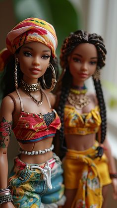 two dolls are standing next to each other wearing head wraps and necklaces on their heads