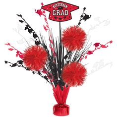 a vase filled with red flowers on top of a white table next to a sign