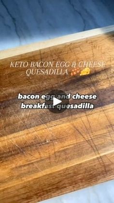 a wooden cutting board with bacon and cheese on it