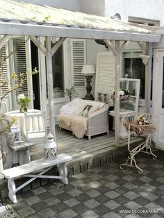 an outdoor room with white furniture and decor