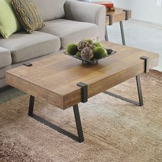 a coffee table sitting on top of a carpeted floor next to a gray couch