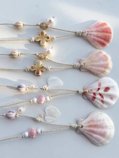 several seashells and pearls are arranged on a white surface, including one shell