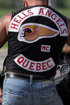 a man with tattoos on his back wearing a motorcycle vest