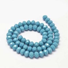 blue glass beads are arranged on a white surface, with one bead in the middle