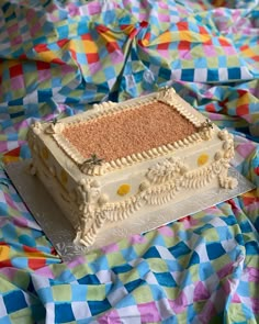 a cake sitting on top of a colorful table cloth