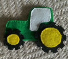 a green and yellow toy tractor sitting on top of a white blanket