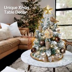 a christmas tree with gold and silver ornaments on it in front of a living room couch