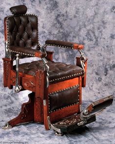 an old fashioned wooden chair with leather upholstered back and foot rests on wheels