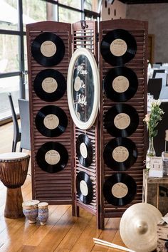 a room divider made out of vinyl records on a wooden table in front of a window