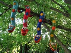 colorful glass owls are hanging from a tree