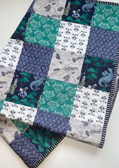 a blue and white patchwork quilt on top of a table