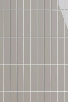 a white tiled wall with gray and white tiles