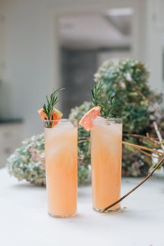 two glasses filled with drinks sitting on top of a table