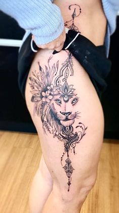 a woman's thigh with tattoos on it and a lion tattoo on the side