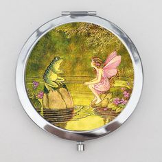 a mirror with a painting of a frog and a fairy sitting on top of a rock