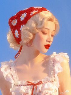 a woman wearing a red and white hat with flowers on it