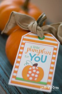 a little pumpkin for you gift tag on a table next to two orange pumpkins