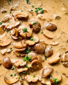 a bowl filled with mushrooms and broccoli covered in gravy