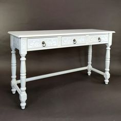 a white table with two drawers on it's legs and one drawer at the top