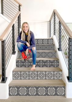 a woman is sitting on the stairs with her red purse and smiling at the camera